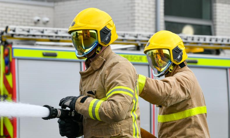 Firefighters spraying water as part of a hose drill