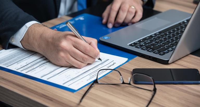 person working at laptop making notes