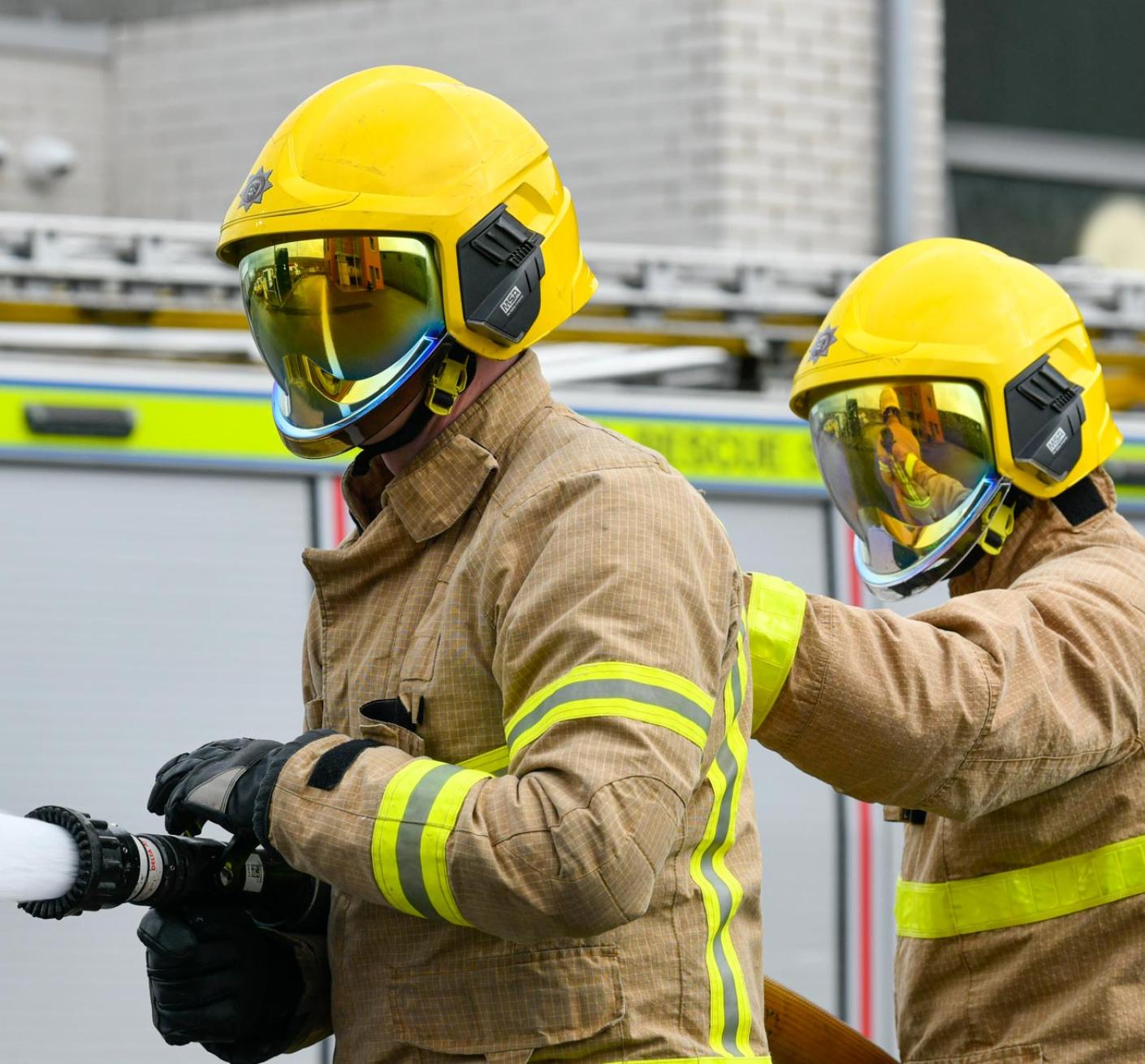 Firefighters spraying water as part of a hose drill