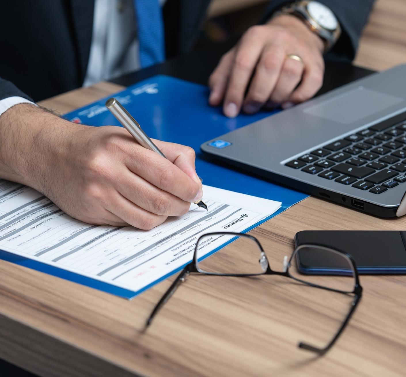 person working at laptop making notes