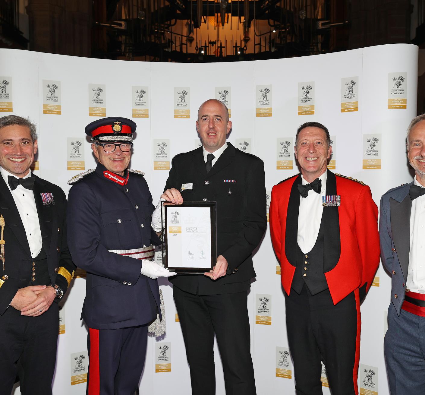 A firefighter is presented an award, flanked by dignitaries