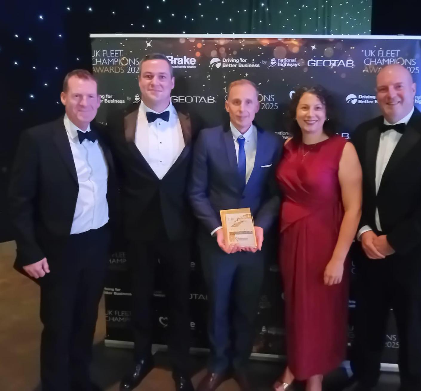 A team of fire and rescue staff pose with an award