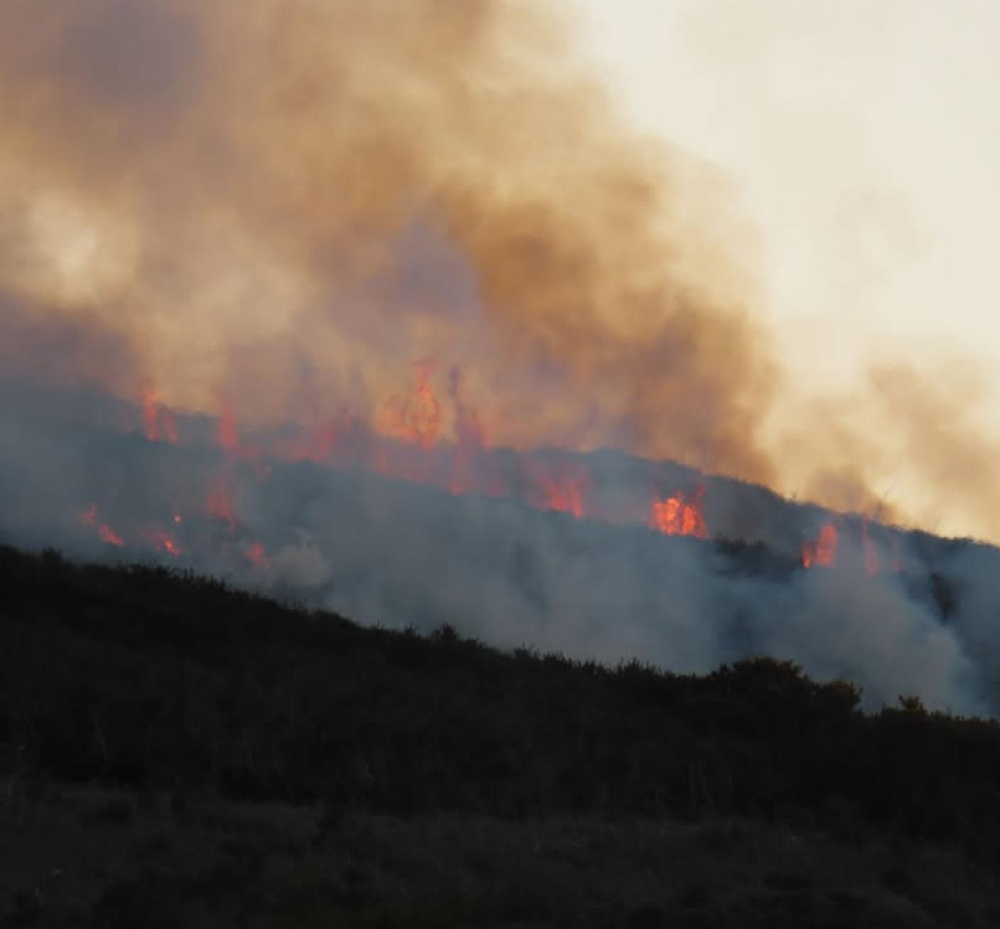 A wildfire seen burning in the countryside