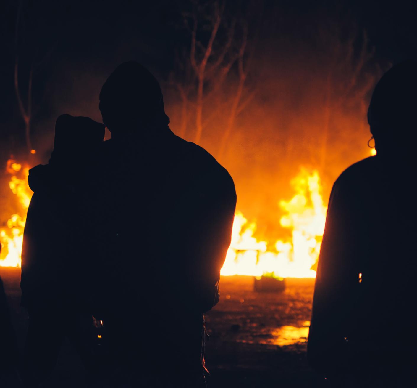 A stock image of shadowy figures in front of a suspected arson incident