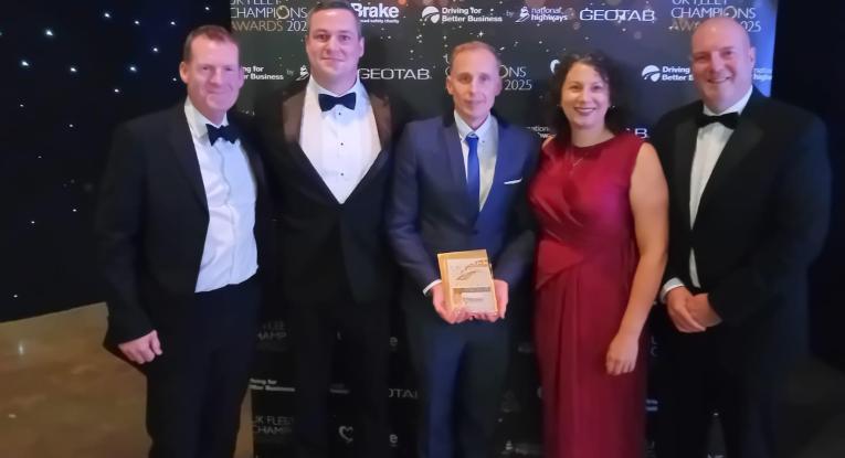 A team of fire and rescue staff pose with an award