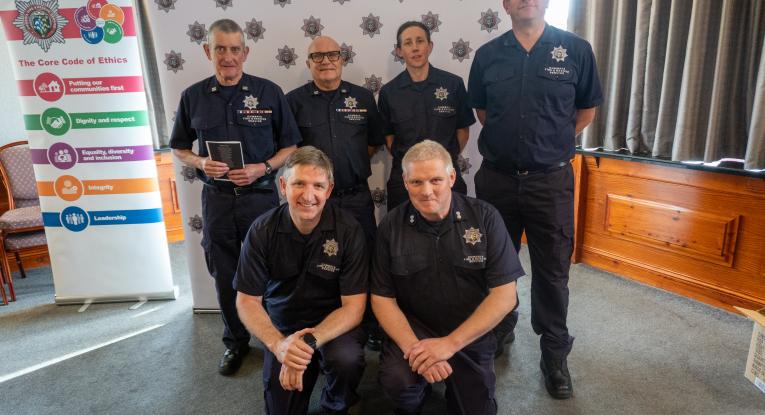 A team of firefighters pose for a photograph at an awards ceremony