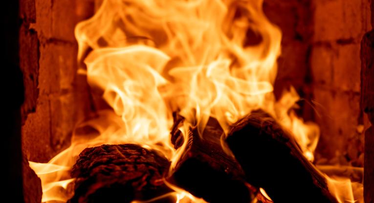 Wood burns in a fireplace
