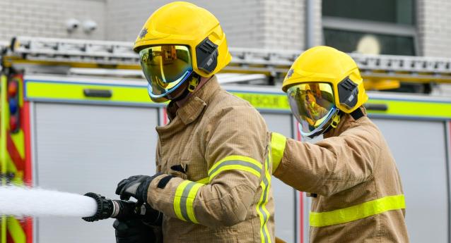 Firefighters spraying water as part of a hose drill